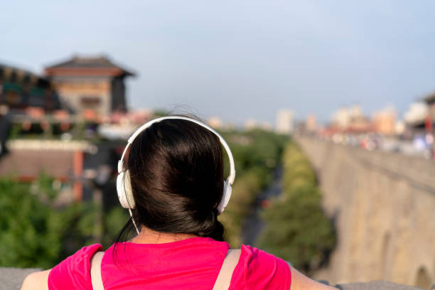 girl listening music on ancient city wall - xian audio imagens e fotografias de stock