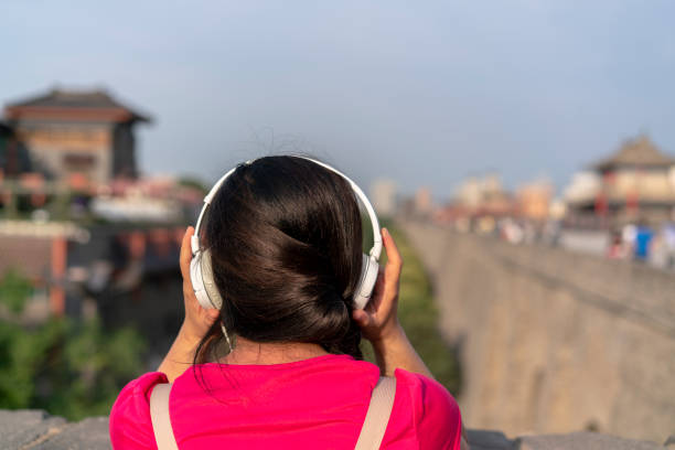 girl écoute musique sur la muraille de la ville antique - xian audio photos et images de collection