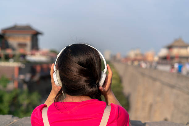 girl listening music on ancient city wall - xian audio imagens e fotografias de stock