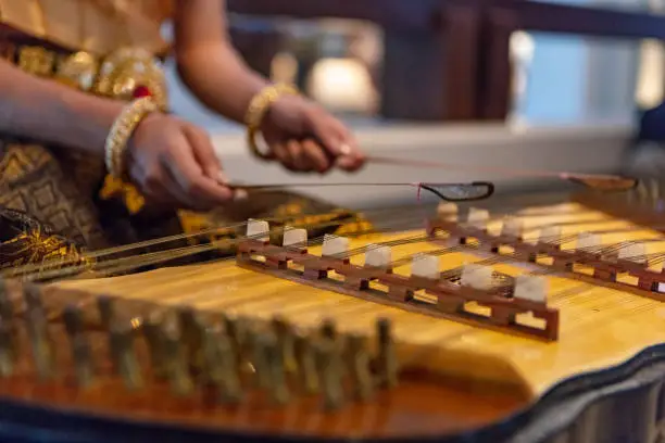 Unrecognizable woman playing hammered dulcimer