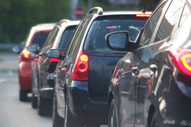 cars stopping at a traffic light cars stopping in front of a red traffic light, with red lighted brake lights tail light stock pictures, royalty-free photos & images