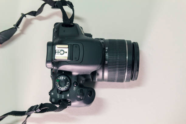 istock Closeup top view of modern black DSLR camera on white background 983214658