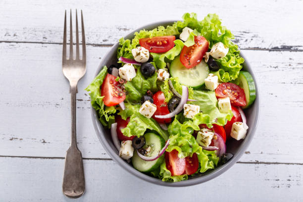 istock Fresh greek salad served in bowl with fork. 983215458