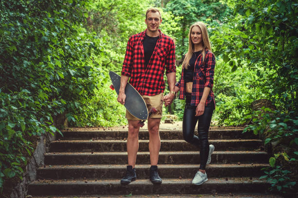 istock Casual moder young skateboarders couple posing on footway. 983219406