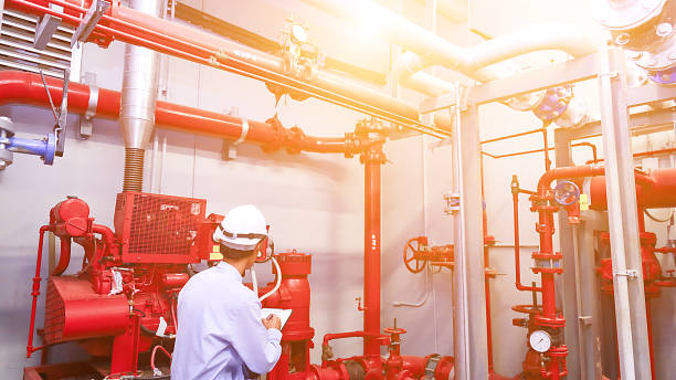 ingénieur vérification rouge générateur pompe pour tuyauterie et alarme incendie contrôle système d’arrosage. - tuyau darrosage photos et images de collection