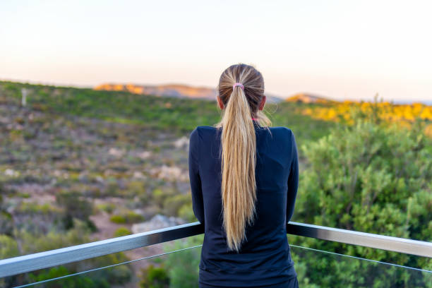 istock Woman on terrace looking at view 983224060