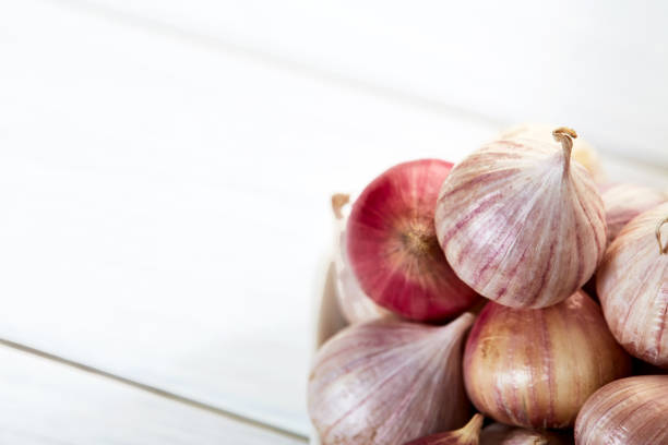 istock Fresh healthy garlic in ceramic bowl on white table 983235746