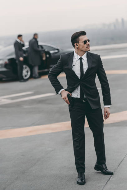 istock handsome bodyguard with security earpiece and gun 983236324