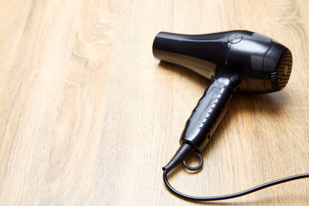 istock black hair dryer on wood background. 983236580