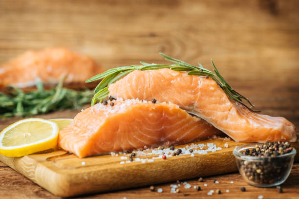 istock Raw salmon fish fillet on wooden background. 983237122