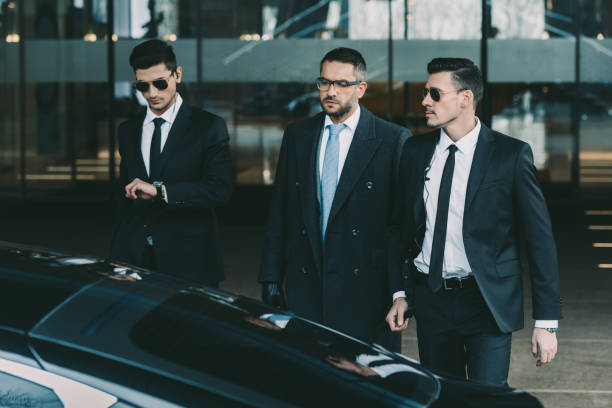 istock two bodyguards going with businessman to black car 983243766