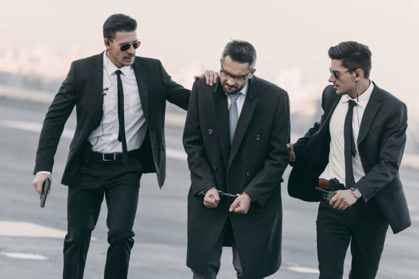 istock security guards with weapon standing with arrested man in handcuffs on helipad 983262382