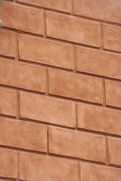 A close-up view of a red brick wall, showcasing detailed texture and pattern. The image has a rustic and industrial feel, suitable for backgrounds or design elements.