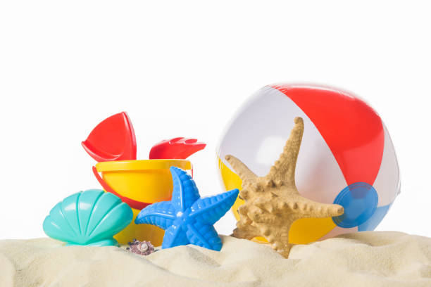 istock Beach ball and toys in sand isolated on white 983277440