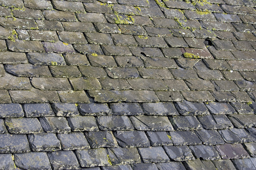Roof shingles with garret house on top of the house. dark asphalt tiles on the roof background on afternoon time. dark asphalt tiles on the roof background