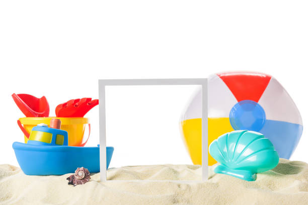 istock Beach toys and frame in sand isolated on white 983284798