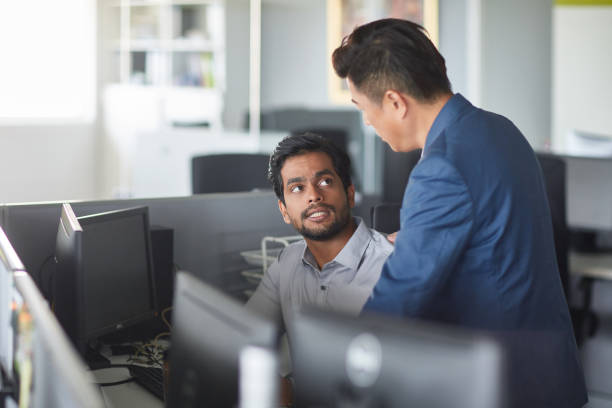 hombres de negocios discutiendo sobre la computadora en el escritorio - cubicle using computer computer office fotografías e imágenes de stock