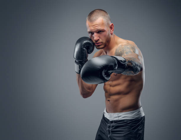 istock Portrait of shaved head fighter over grey background. 983291254