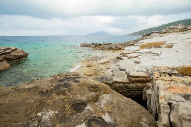 Overcast sky and the Sea bay in the Aegean Sea in the Bodrum area. Stones on the sea shore.