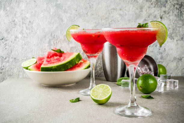 Watermelon margarita cocktail Watermelon margarita cocktail with lime and sliced watermelon, light concrete background copy space daiquiri stock pictures, royalty-free photos & images