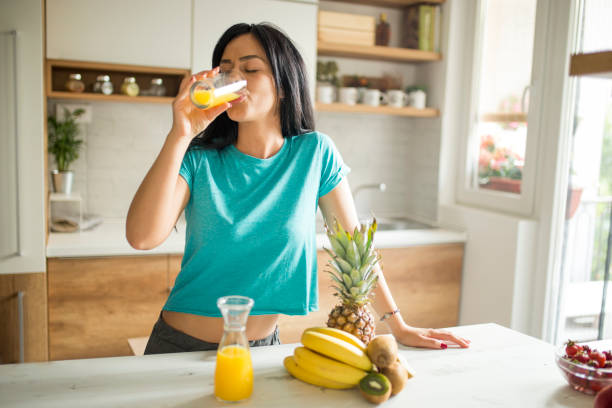 routine mattutina - women juice drinking breakfast foto e immagini stock