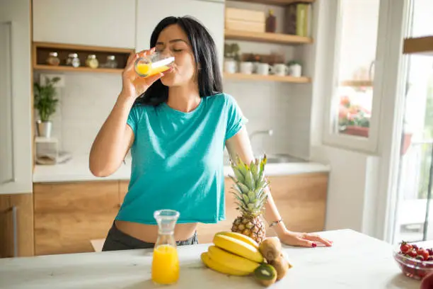 Young woman enjoying fresh orange juice