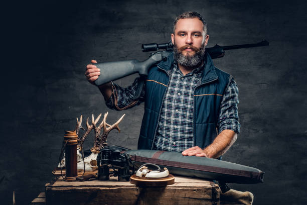 Bearded modernl hunter with his trophy holds a rifle. stock photo