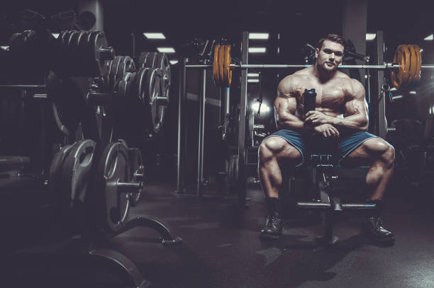 istock Brutal strong bodybuilder athletic men pumping up muscles with dumbbells 983324876