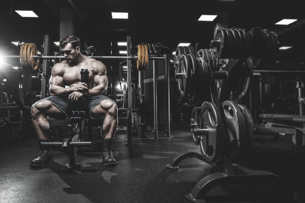 istock Brutal strong bodybuilder athletic men pumping up muscles with dumbbells 983325380