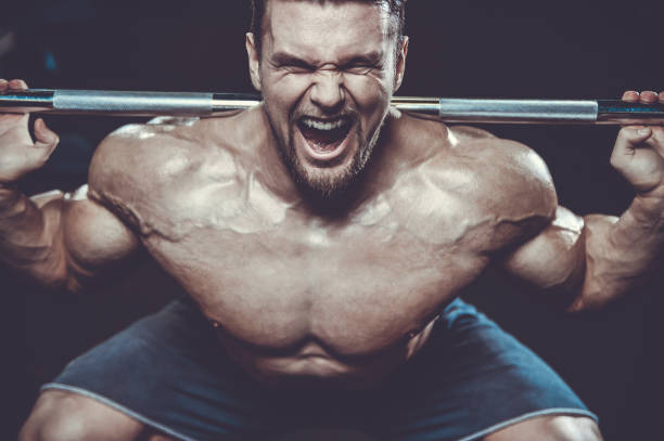 istock Brutal strong bodybuilder athletic men pumping up muscles with dumbbells 983326080