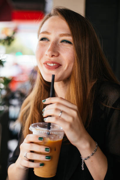 istock Smiling woman drinking iced coffee 983336966