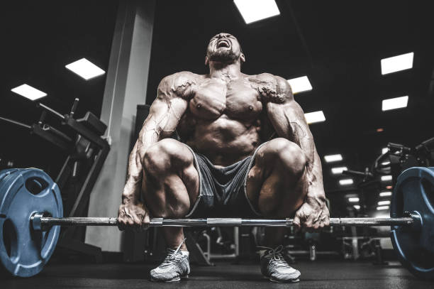 istock Handsome model young man training legs in gym 983337026