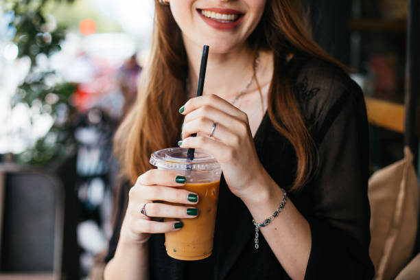 uśmiechnięta kobieta pijąca mrożoną kawę - iced coffee zdjęcia i obrazy z banku zdjęć