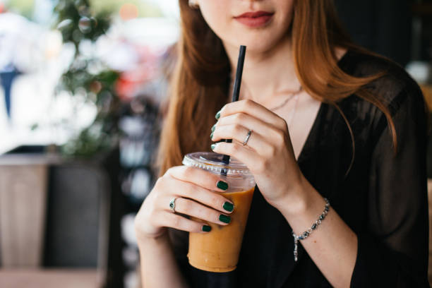 istock Smiling woman drinking iced coffee 983337552