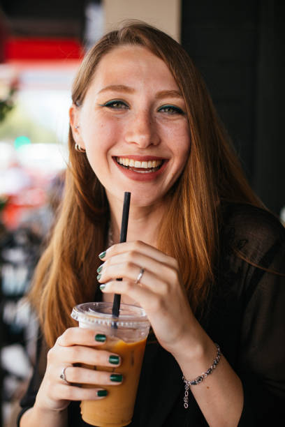 istock Smiling woman drinking iced coffee 983337576