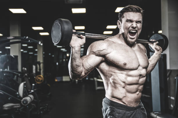 istock Handsome model young man training legs in gym 983342458
