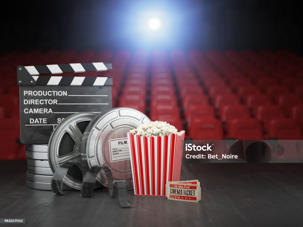 Cinema, movie or home video concept background. Film reels, clapper board  and pop corn in the theater movie cinema screen with empty seats. Cinema, movie or home video concept background. Film reels, clapper board  and pop corn in the theater movie cinema screen with empty seats. 3d illustration Movie Theater Stock Photo