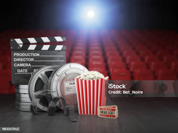 Cinema Movie Or Home Video Concept Background Film Reels Clapper Board And Pop Corn In The Theater Movie Cinema Screen With Empty Seats Stock Photo - Download Image Now