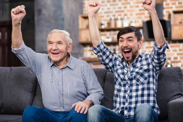 istock Cheerful men watching football at home 983347368