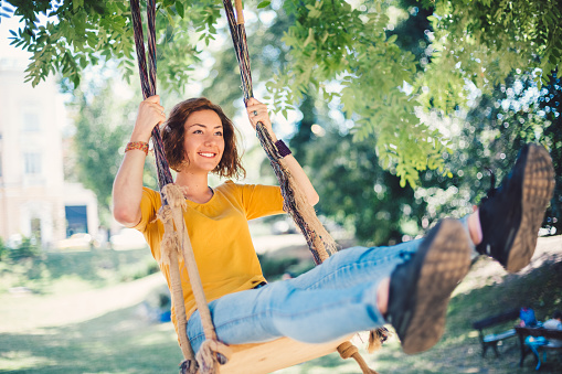 Girl swinging in the city park