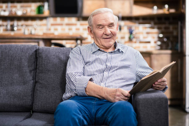 istock Joyful senior man reading with pleasure 983349994