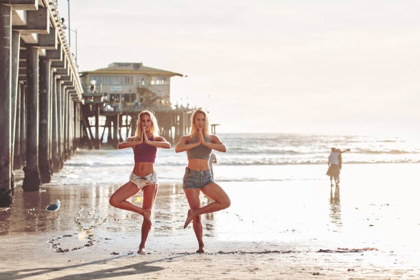 istock Twins exercising at sunset at the beach 983350652