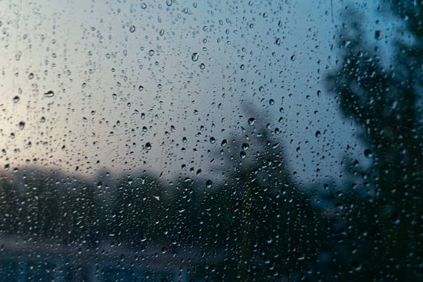 istock Window glass covered with raindrops at sunset 983363038