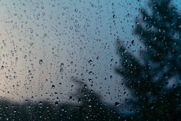 istock Window glass covered with raindrops at sunset 983363072
