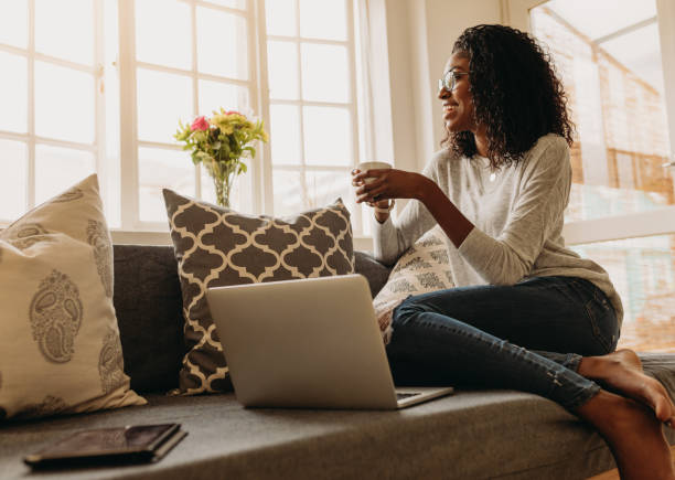 istock Woman enjoying a cup of coffee while working on laptop 983363278