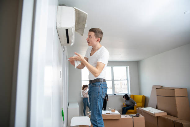 The young man cleaning filters in the air-conditioning split device in the recently rented apartment The young man cleaning filters in the air-conditioning split device, in the recently rented apartment in Brooklyn, New York, USA air conditioner family stock pictures, royalty-free photos & images