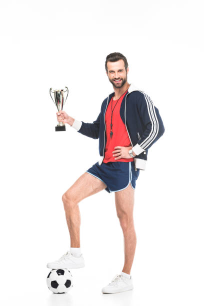 istock soccer trainer with trophy cup and ball, isolated on white 983367976