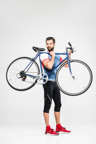 istock handsome sportsman carrying bicycle, isolated on white 983368054