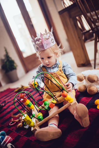 istock Cute girl having fun playing with educational toy at home 983382542