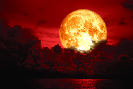 full blood moon over silhouette heap cloud on sea, Elements of this image furnished by NASA